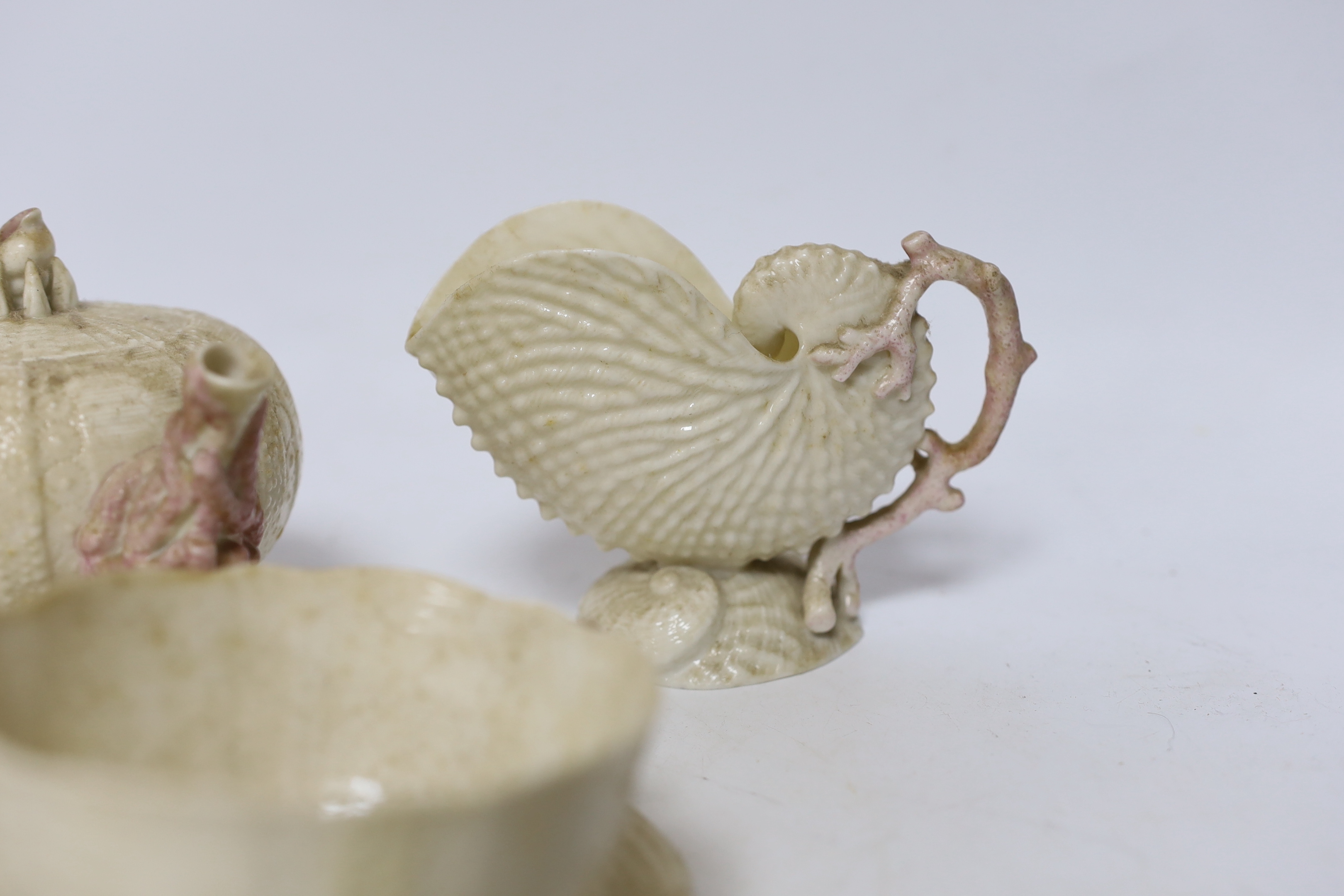 A quantity of Belleek including a teapot, three cups and saucers and a shell design vase, mostly first period